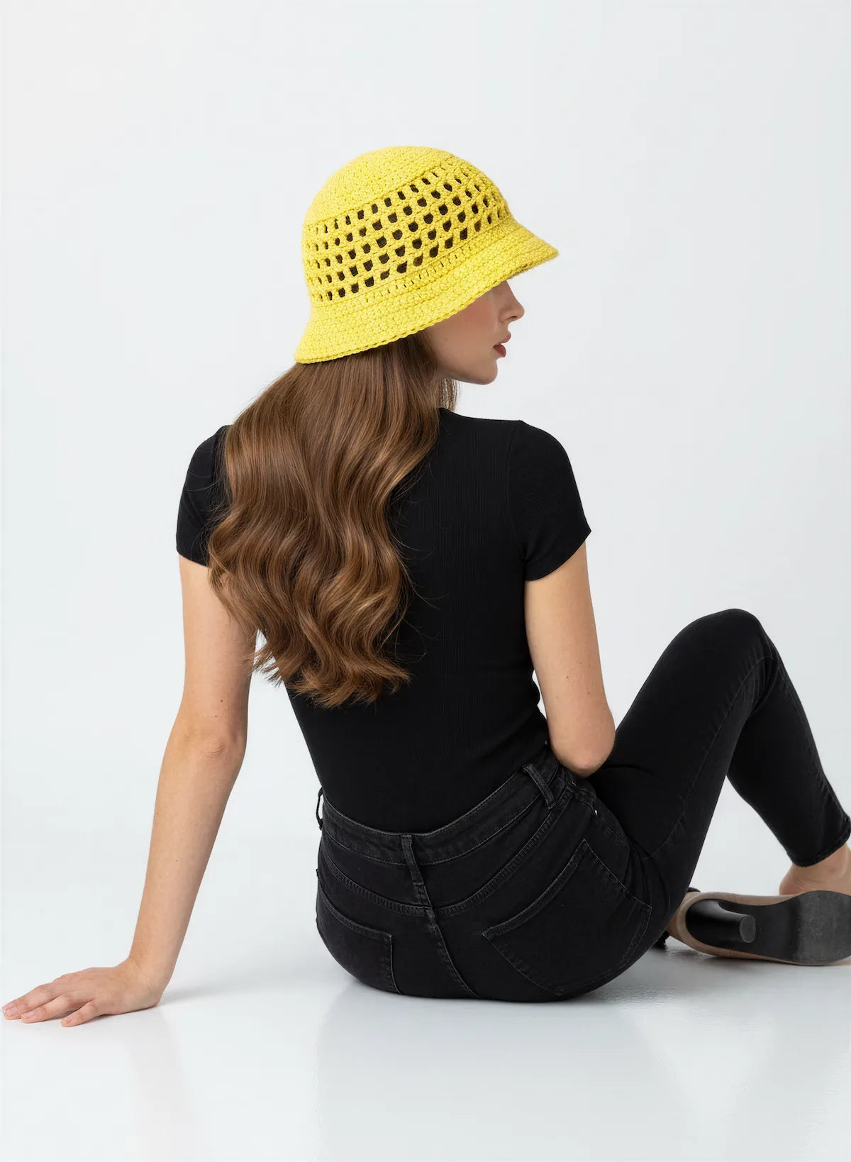 Chapeau Bobbysol – vue de dos assise – bucket hat crochet jaune soleil résille ajourée bord tressé – Cachalabibi