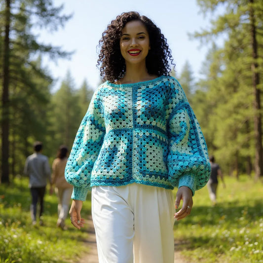 Pull au crochet fait main Bora-Bora de Cachalabibi - bleu - porté par une jeune femme sur un sentier forestier
