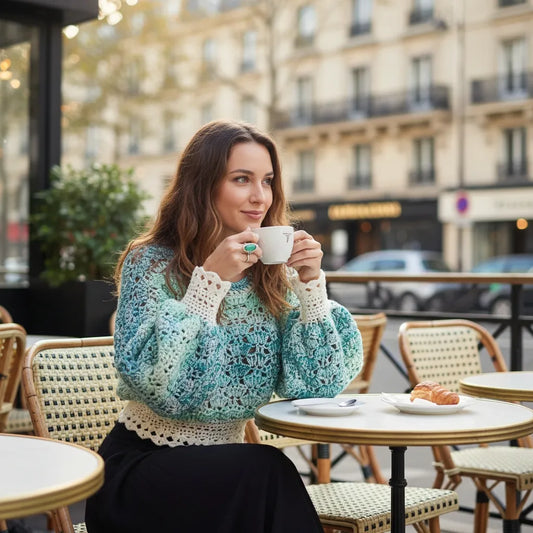 Pull au crochet fait main Fidji de Cachalabibi - turquoise - vue de face d'une femme à la terrasse d'un café