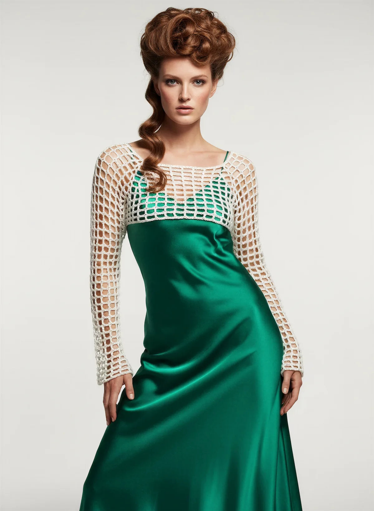 Crop Top Avorio – vue de face plein pied – crop top crochet fait main écru résille grande maille manches longues encolure bateau sur robe satinée vert émeraude – Cachalabibi