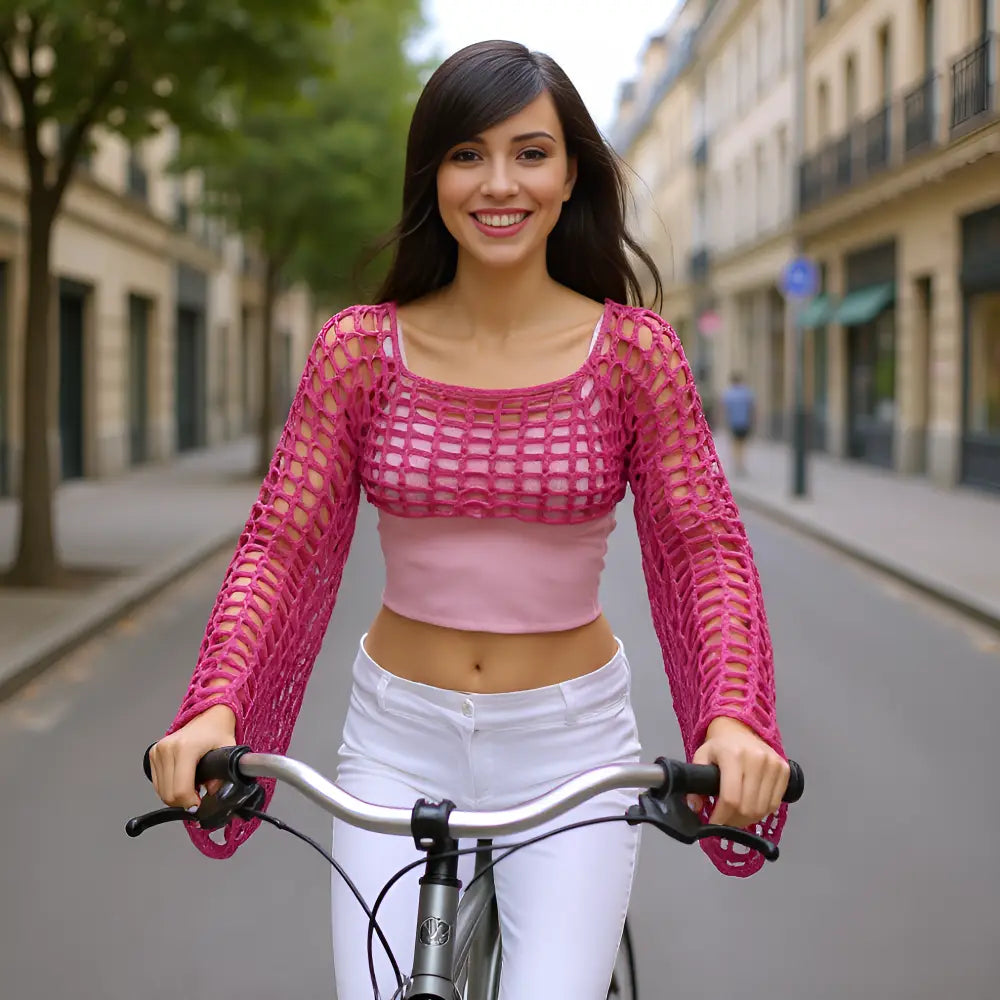 Crop top au crochet fait main Fuschiamo de Cachalabibi - fuchsia - vue de face à vélo dans les rues de Paris