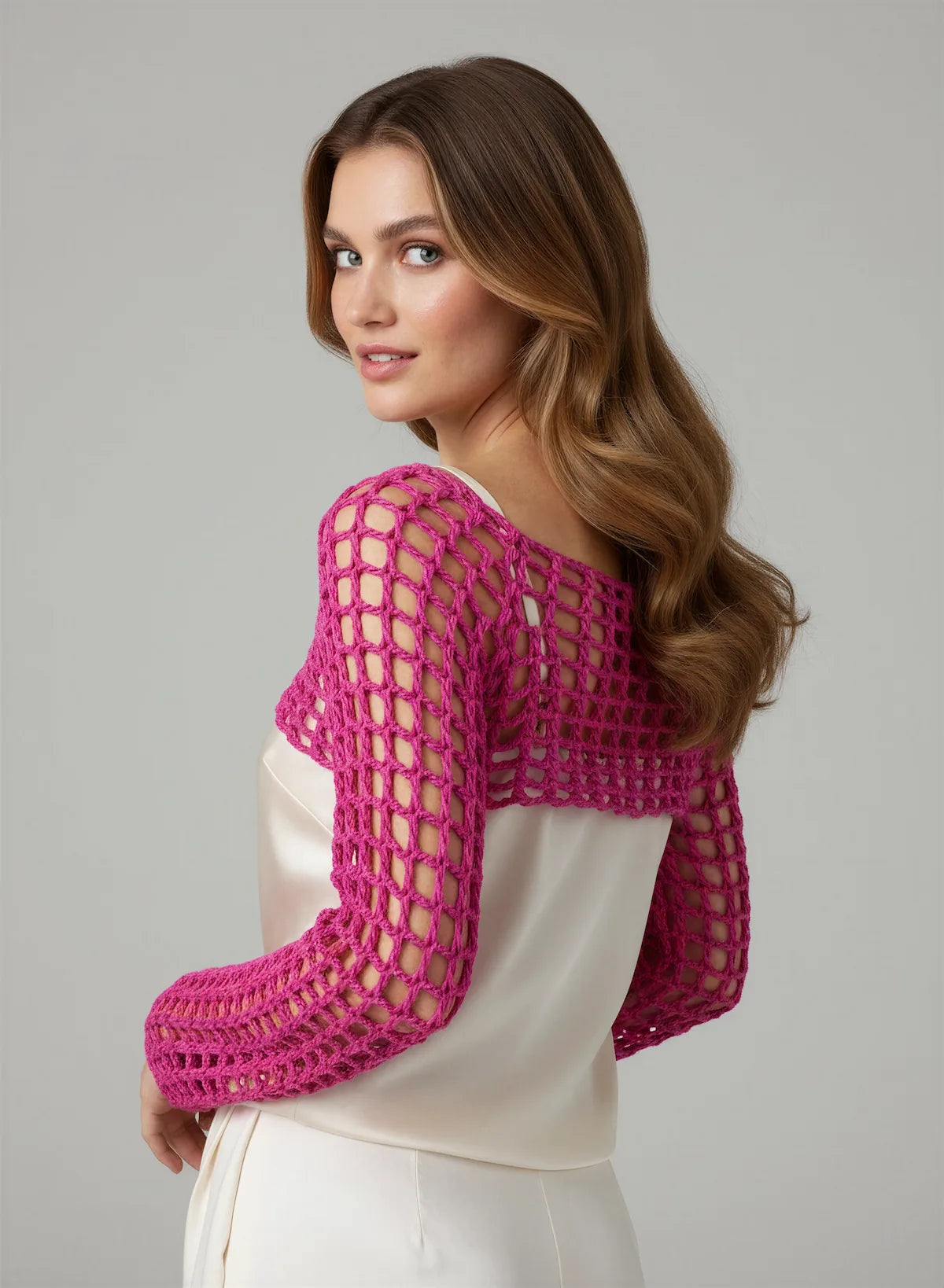 Crop Top Fuschiamo – vue dos 3/4 regard épaule souriant – crop top crochet fait main fuchsia manches évasées résille encolure dos bateau – Cachalabibi