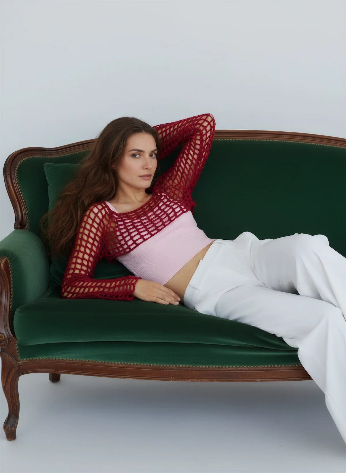 Crop Top Veneziano – vue de face allongée canapé velours – crop top crochet fait main bordeaux manches résille grande maille pose éditoriale – Cachalabibi