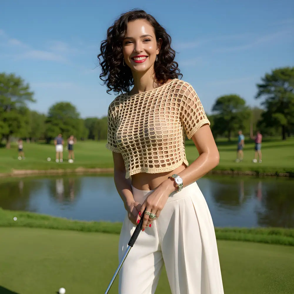 Haut au crochet fait main Kobieta de Cachalabibi - beige foncé - vue de face d'une femme avec pantalon blanc sur un green de golf