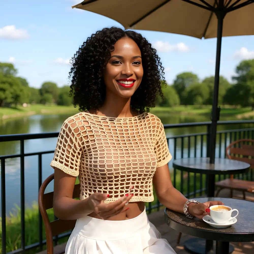 Haut au crochet fait main Kobieta de Cachalabibi - beige foncé - vue de face d'une jeune femme qui prend un café en terrasse