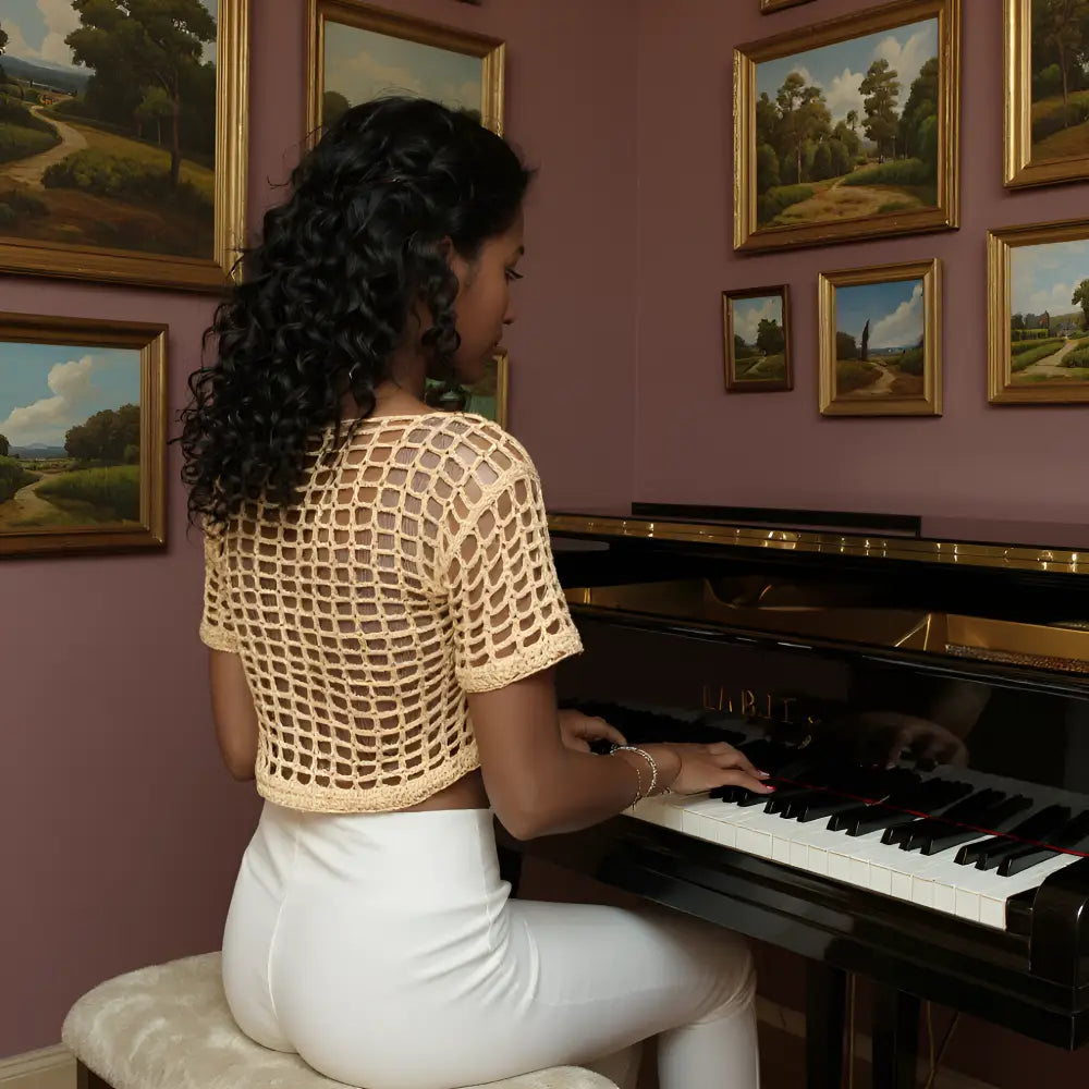 Haut au crochet fait main Kobieta de Cachalabibi - beige foncé - vue de dos d'une femme qui joue du piano dans un salon