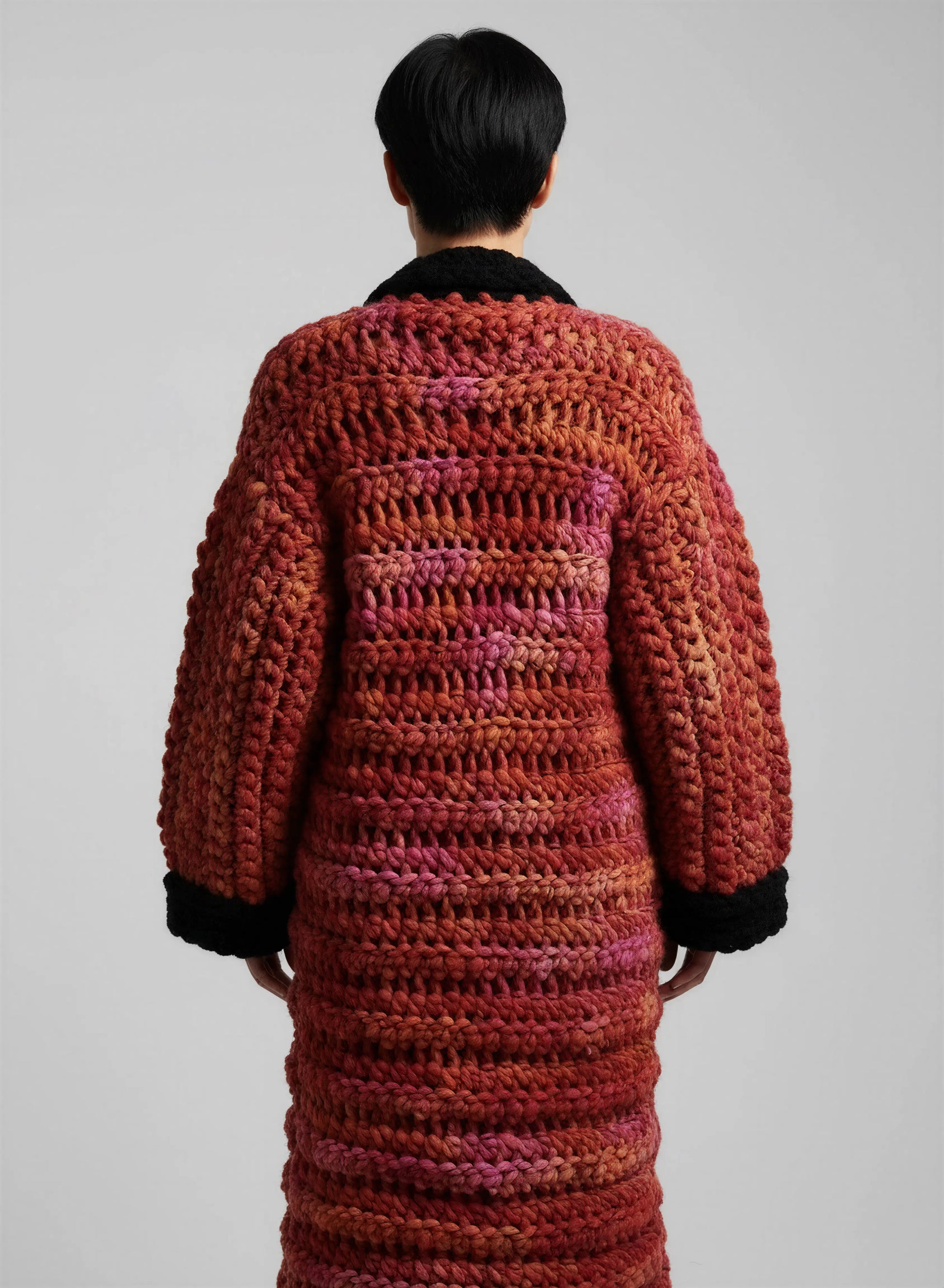 Manteau crochet fait main Kozakine rouge orange chiné grosse maille maxi dos manchettes noires festonnées – de dos - Cachalabibi