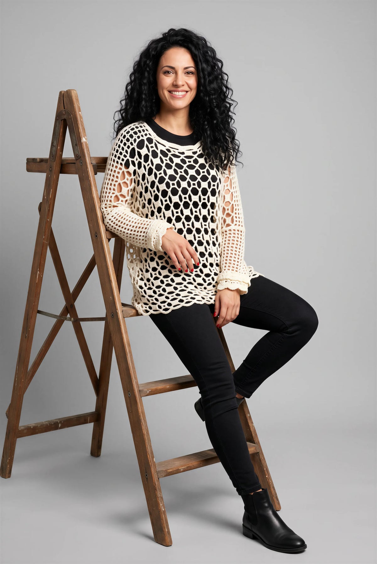Poncho Buco crochet blanc — mise en scène assise sur échelle — Cachalabibi