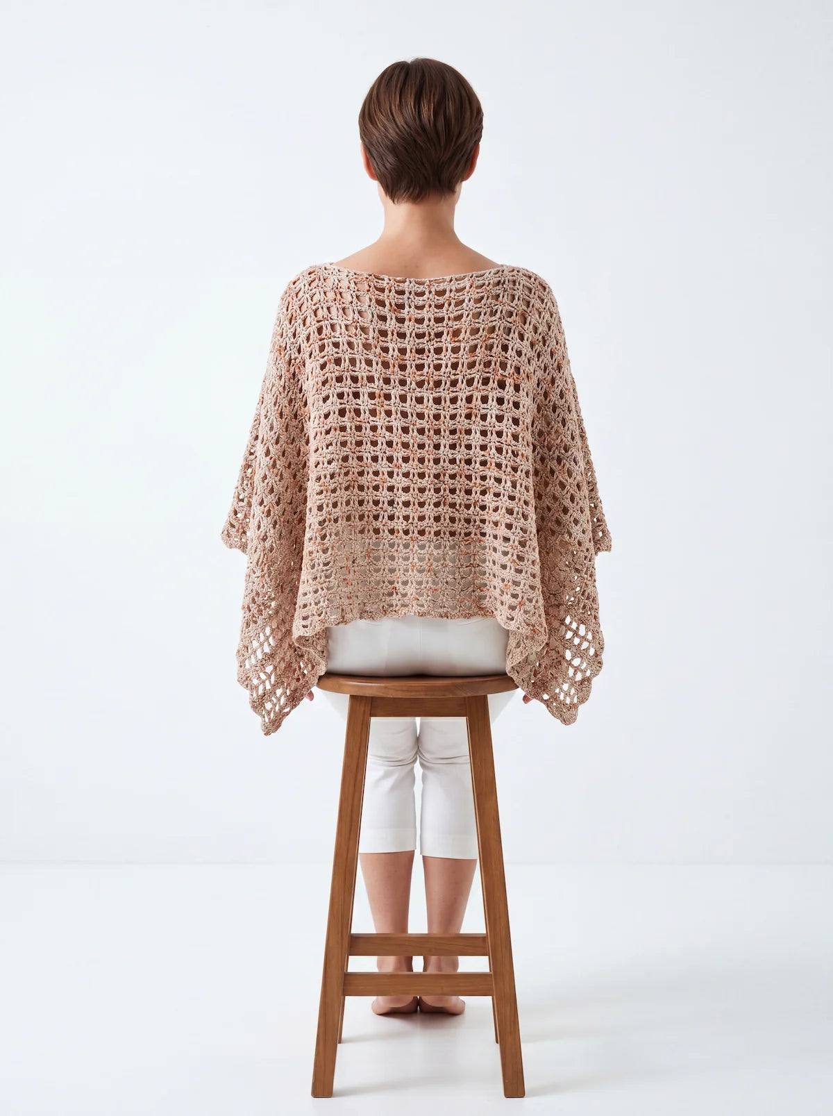 4.	Poncho femme Galao au crochet, vue de dos assise, coupe asymétrique, point filet ajouré, coton beige — Cachalabibi