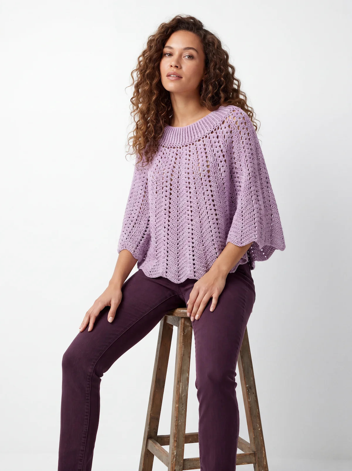 2.	Poncho femme Violyne au crochet lilas, vue de face assise, manches 3/4 évasées bordure festonnée, coupe ample — création Cachalabibi