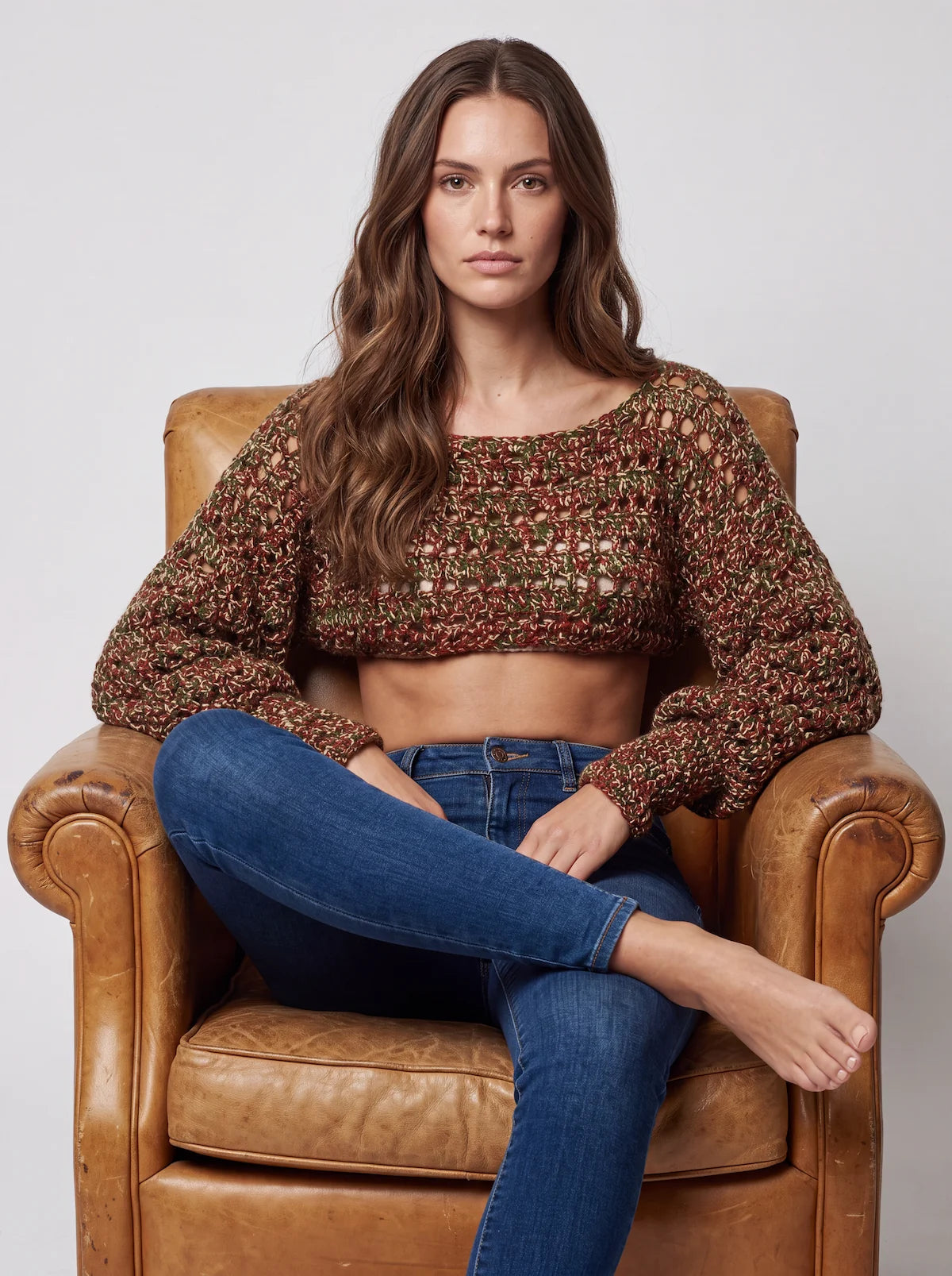 Pull court Mélango chiné rouille vert ajouré – assise dans un fauteuil de cuir – Cachalabibi