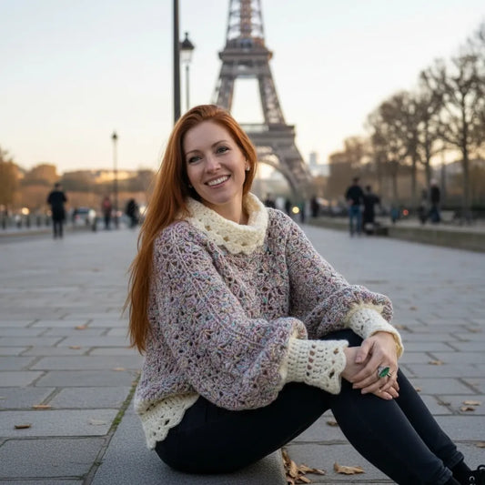 Pull au crochet fait main Unico de Cachalabibi - chiné pastel - vue de face assise sur un trottoir parisien avec la Tour Eiffel au loin