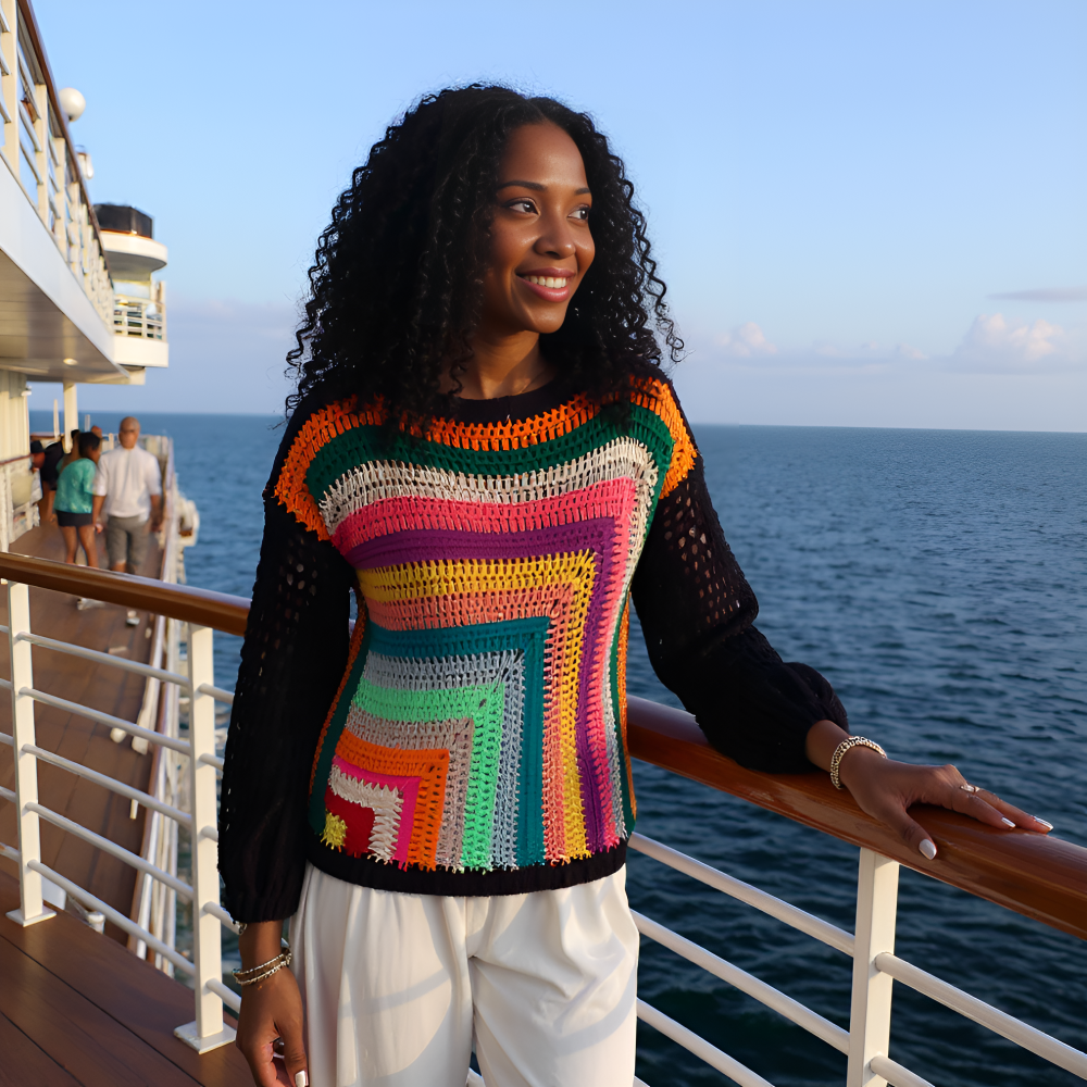 Pull au crochet fait main Vasarello de Cachalabibi - multicolore - porté par une jeune femme sur le pont d'un bateau