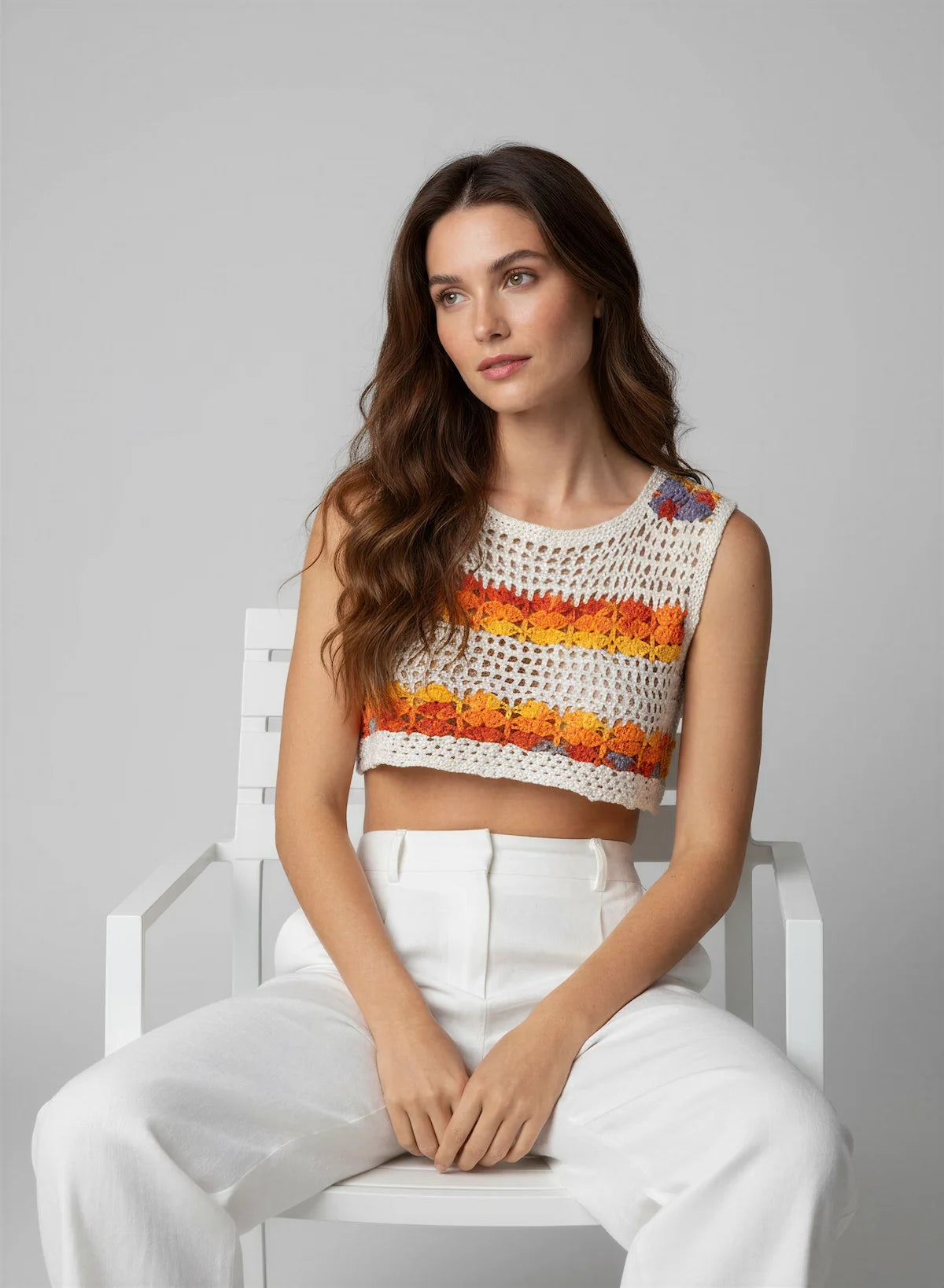 Top Nemusia – vue de face assise – top crochet fait main blanc rayures florales multicolores encolure ronde sans manches – Cachalabibi