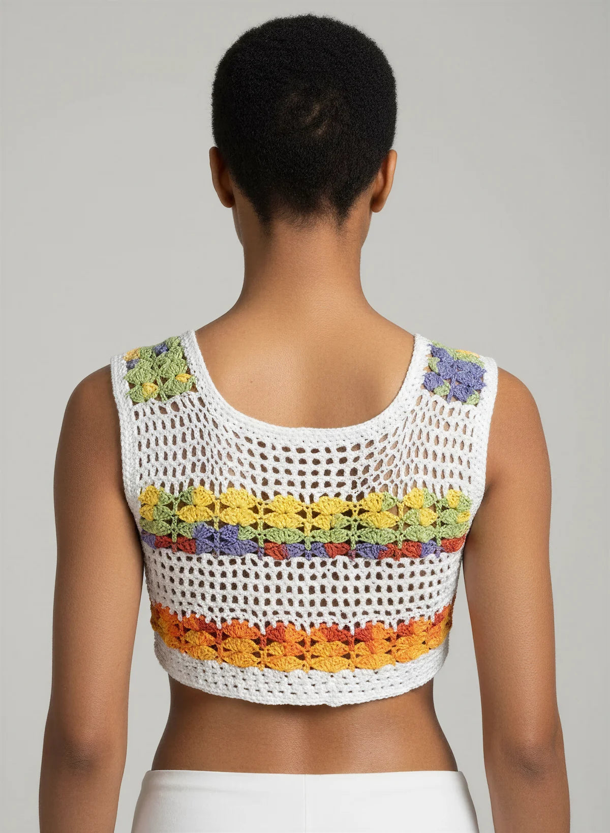 Top Nemusia – vue dos 3/4 bras levés – top crochet fait main blanc motif résille rayures florales multicolores dos – Cachalabibi